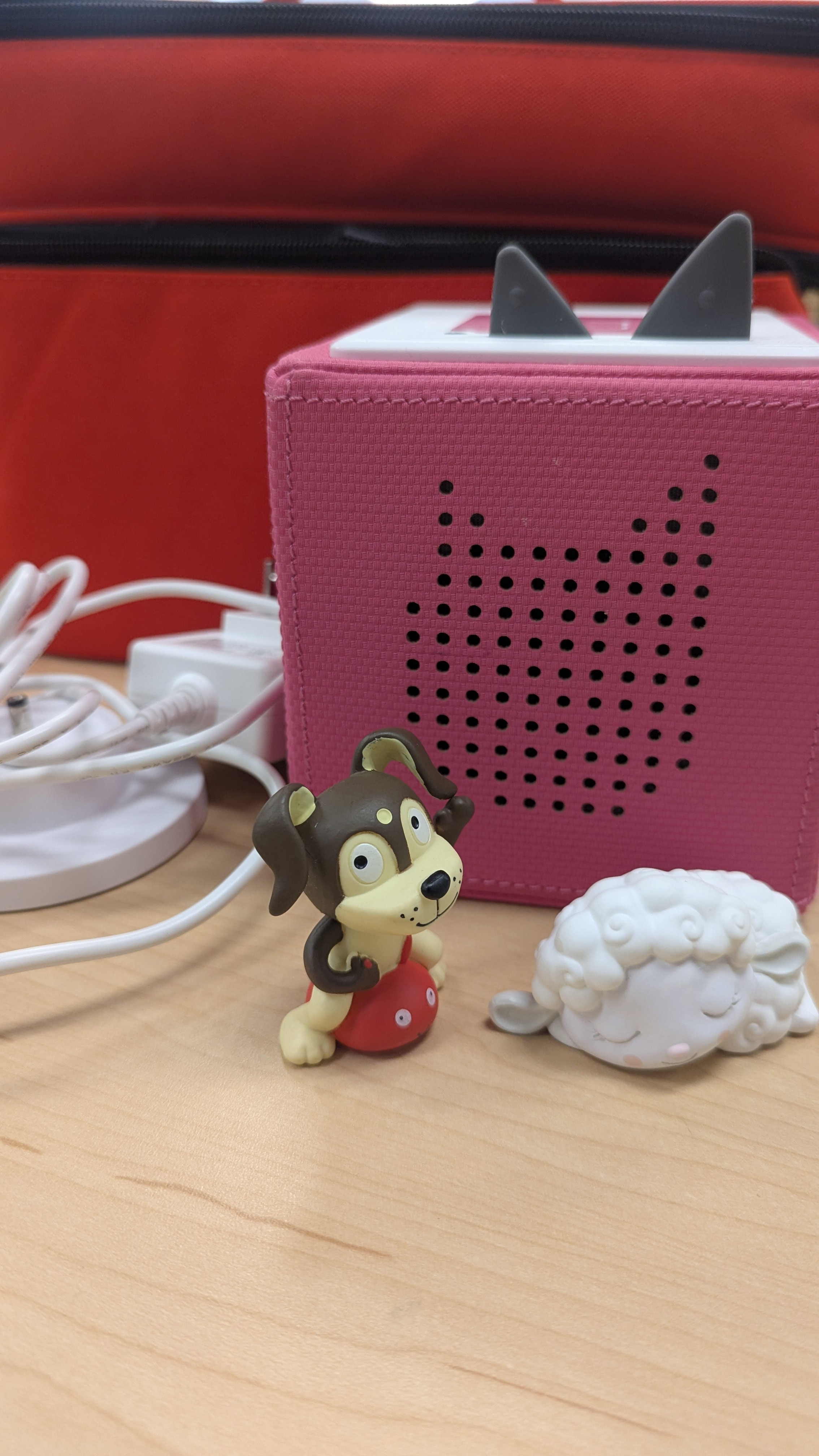 Pink TonieBox pictured with "Playful Puppy" and "Sleepy Sheep" Tonie Figurines in front. 