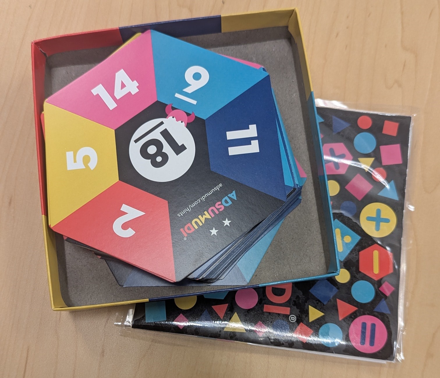 Board game box with hexagon cards and instruction booklet