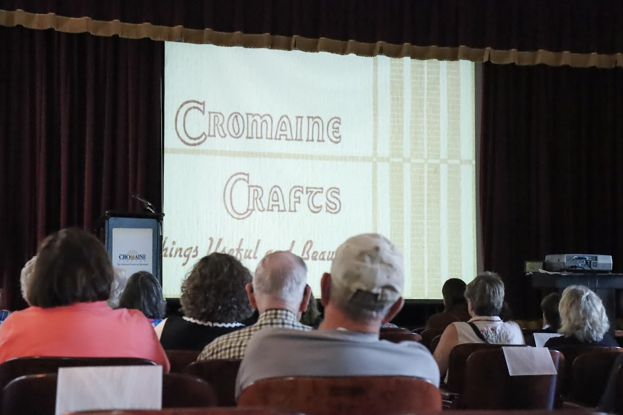 An audience watches the Weaving Heritage video in the Music Hall. 