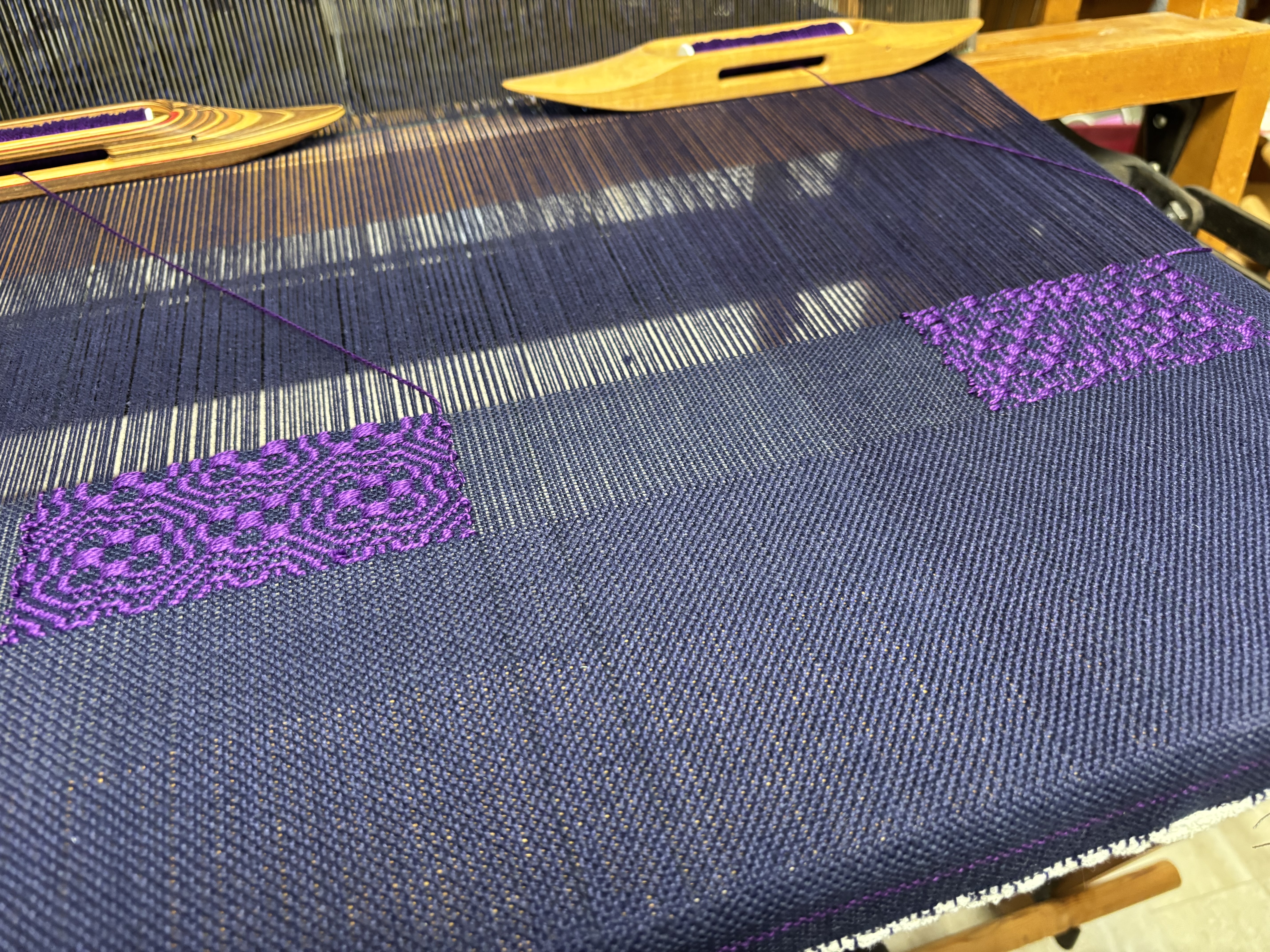 Blue and purple fibers comprise a section of the textile.