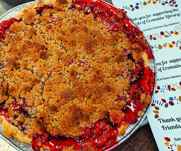 A homemade pie, next to tags that read "Thank you for supporting the Friends of Cromaine Library!"