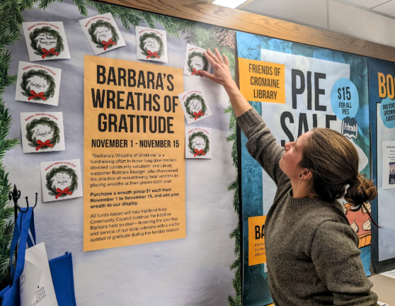 Shelby adds her wreath pinup to the display honoring Barbara Krueger and her wreaths for veterans. 