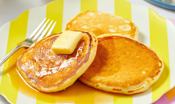 Pancakes on a yellow striped plate. 
