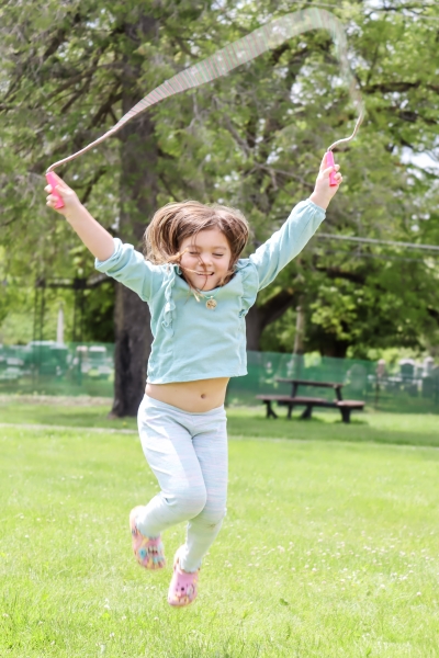 A girl on the South Lawn hopping with a jump rope. 