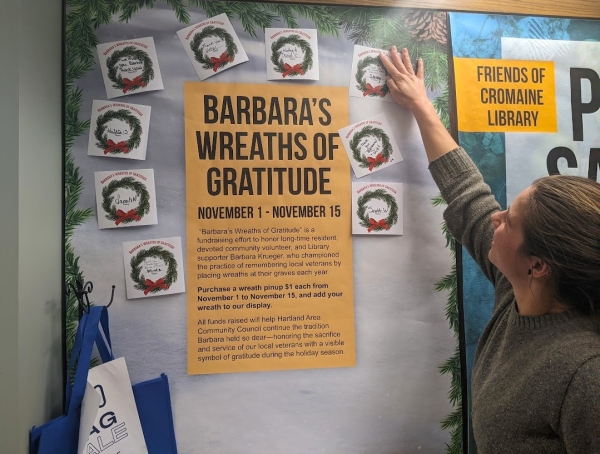 Shelby adds her wreath pinup to the display honoring Barbara Krueger and her wreaths for veterans. 
