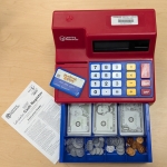 Image of an open toy cash register with money and a play credit card. 