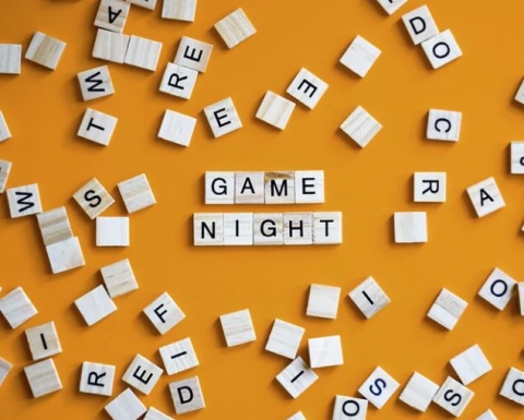 "Game Night" spelled out with letter game pieces, with other pieces around it. 