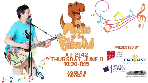 white male (Evan) playing guitar with image of dinosaur nearby