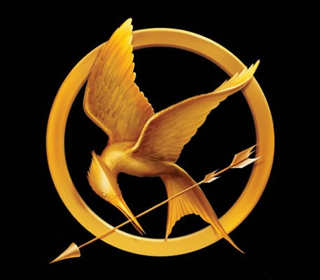 The Hunger Games mockingjay logo, in gold, with a black background. 