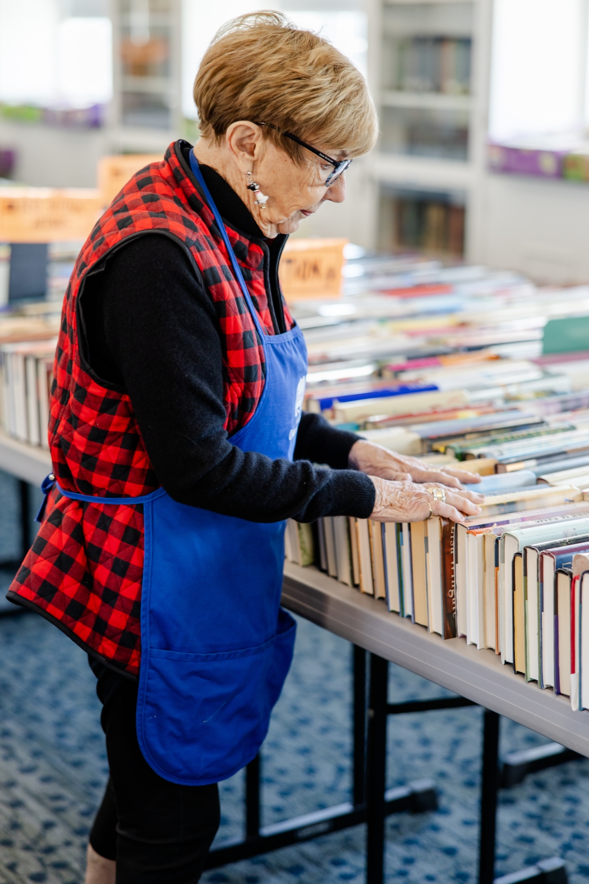 Mary Lynn in a Friends apron, filing books on the third floor in preparation for the Book Sale. 