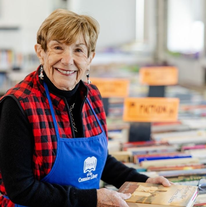 Mary Lynn in a Friends apron, filing books on the third floor in preparation for the Book Sale. 